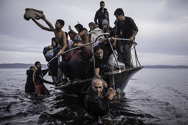 Sergey Ponomarev  November 16, 2015. Migrants arrive by a Turkish boat near the village of Skala, on the Greek island of Lesbos. The Turkish boat owner delivered some 150 people to the Greek coast and tried to escape back to Turkey; he was arrested in Turkish waters. Series: Europe Migration Crisis 2015. © Prix Pictet Space